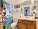 Bathroom with toilet, mario theme shower curtain, and wood cabinets at 270 Earlmont Pl, Davenport, FL 33896