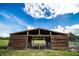 Wooden barn with open stalls and grassy field at 4121 Albritton Rd, St Cloud, FL 34772