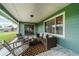 Covered back patio with wicker furniture and rural view at 4121 Albritton Rd, St Cloud, FL 34772