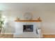 Modern white brick fireplace with a wood mantel and decorative accents at 4121 Albritton Rd, St Cloud, FL 34772