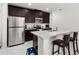 Modern kitchen with island, stainless steel appliances, and dark wood cabinets at 4919 Conifer Cone Dr, Kissimmee, FL 34746