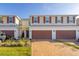 Two-story townhome with a two-car garage and landscaped yard at 4919 Conifer Cone Dr, Kissimmee, FL 34746