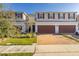 Townhouse exterior featuring a two-car garage and brick driveway at 4919 Conifer Cone Dr, Kissimmee, FL 34746