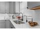 Gray kitchen cabinets, white backsplash and farmhouse sink at 632 Pinewood Dr, Davenport, FL 33896