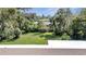 Large backyard with lush green grass and mature trees at 905 Valencia Rd, South Daytona, FL 32119
