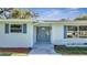Front entrance with a freshly painted teal door and gray shutters at 905 Valencia Rd, South Daytona, FL 32119