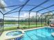 Inviting screened pool and spa overlooking a tranquil lake at 973 Lake Berkley Dr, Kissimmee, FL 34746