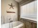 Relaxing bathroom with soaking tub, tile shower, and modern fixtures at 973 Lake Berkley Dr, Kissimmee, FL 34746
