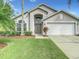 Two-story house with a two-car garage, landscaping, and a green lawn at 973 Lake Berkley Dr, Kissimmee, FL 34746
