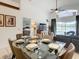 Bright dining area with glass table and seating for six, offering views into the living room and backyard at 973 Lake Berkley Dr, Kissimmee, FL 34746