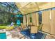 Covered patio with pool access, table, chairs, and hanging chair at 9016 Murano Mews Ct, Kissimmee, FL 34747