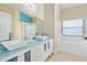 Modern bathroom with double vanity, large mirror, and a soaking tub at 9016 Murano Mews Ct, Kissimmee, FL 34747