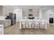 Kitchen island with white quartz countertop and four white counter stools at 14442 Noto Ave, Clermont, FL 34714