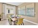 Bright dining room with wood table, yellow chairs, and large artwork at 4060 Bannock Ave, Tavares, FL 32778
