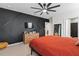 Modern bedroom with a stylish dark accent wall and dresser at 6883 Botanic Blvd, Harmony, FL 34773