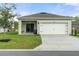 House exterior showcasing a two-car garage and covered patio at 6883 Botanic Blvd, Harmony, FL 34773