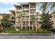 Three-story building with screened balconies and lush landscaping at 9051 Treasure Trove Ln # 307, Kissimmee, FL 34747