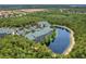 Aerial view of community, featuring resort-style pool, pond, and lush landscaping at 9051 Treasure Trove Ln # 307, Kissimmee, FL 34747