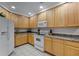 Kitchen with wood cabinets, granite counters, appliances at 9051 Treasure Trove Ln # 307, Kissimmee, FL 34747