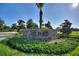 The Plaza community entrance features a stone sign and lush landscaping at 1423 Bunker Dr, Davenport, FL 33896