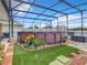 Landscaped backyard oasis featuring a round above ground pool and screened enclosure at 1927 Partin Terrace Rd, Kissimmee, FL 34744