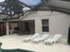 Relaxing poolside patio with lounge chairs and outdoor dining set at 236 Paradise Woods Ct, Davenport, FL 33896