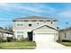 Two-story house with a green exterior, white garage door, and landscaping at 4963 Royal Point Ave, Kissimmee, FL 34746