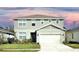 Two-story house with light green vinyl siding, white trim, and a two-car garage at 4963 Royal Point Ave, Kissimmee, FL 34746