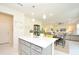 Open concept kitchen with island, gray cabinets and yellow barstools at 4963 Royal Point Ave, Kissimmee, FL 34746