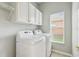 Laundry room with white washer, dryer, and cabinets at 540 Genoa Dr, Poinciana, FL 34759