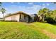 House back view with lush lawn and pool enclosure at 561 Sienna Dr, Poinciana, FL 34759