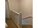 Upper level carpeted stairs with white railings and a door at 660 Celebration Ave # 260, Kissimmee, FL 34747