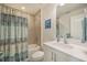 Bathroom with tub/shower combo, white vanity and teal shower curtain at 709 Benoi Dr, Davenport, FL 33896