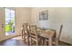 Dining area with a wooden table and four chairs, near sliding door to backyard at 709 Benoi Dr, Davenport, FL 33896