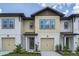Two-story townhome with light-colored siding and a two-car garage at 709 Benoi Dr, Davenport, FL 33896