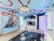 Space-themed bedroom with bunk beds, mural, and a ceiling design resembling a roller coaster at 9158 Wedge Dr, Davenport, FL 33896
