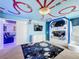 Space-themed bedroom with custom bunk beds and a mural, plus a view of a home theater at 9158 Wedge Dr, Davenport, FL 33896