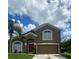 Two-story home with red door and attached garage at 1021 Hacienda Cir, Kissimmee, FL 34741