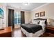King-size bed, hardwood floors, and large window with curtains at 1301 Tuscan Ter # 9106, Davenport, FL 33896