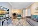 Bright living room features hardwood floors, a comfy couch, and a large TV at 1301 Tuscan Ter # 9106, Davenport, FL 33896