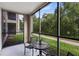 Relaxing screened patio with table and chairs, overlooking a lush green space at 1301 Tuscan Ter # 9106, Davenport, FL 33896