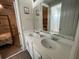 Double vanity bathroom with white cabinets and a view of a bedroom at 1799 Caribbean View Ter, Kissimmee, FL 34747