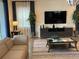 Living room features a large TV, sectional sofa, and geometric wall decor at 1799 Caribbean View Ter, Kissimmee, FL 34747
