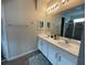 Double vanity bathroom with white cabinets and a large mirror at 1799 Caribbean View Ter, Kissimmee, FL 34747