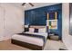 Stylish bedroom with navy blue accent wall and king-size bed at 2133 Pine Oak Loop, Davenport, FL 33837