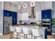 Modern kitchen with blue cabinets, stainless steel appliances, and a large island at 2133 Pine Oak Loop, Davenport, FL 33837