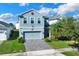 Two-story house with gray siding, gray paver driveway, and landscaping at 3004 Ballad Rd, Kissimmee, FL 34746