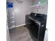 Bright laundry room, featuring a washer, dryer, and shelving at 3077 Brenton Manor Loop, Winter Haven, FL 33881