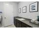 Well-appointed laundry room with granite countertop and dark wood cabinets at 5075 Twin Lakes Blvd, St Cloud, FL 34772