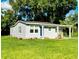 Newly renovated home with gray siding, landscaping, and a blue door at 639 Shore Acres Dr, Lakeland, FL 33801